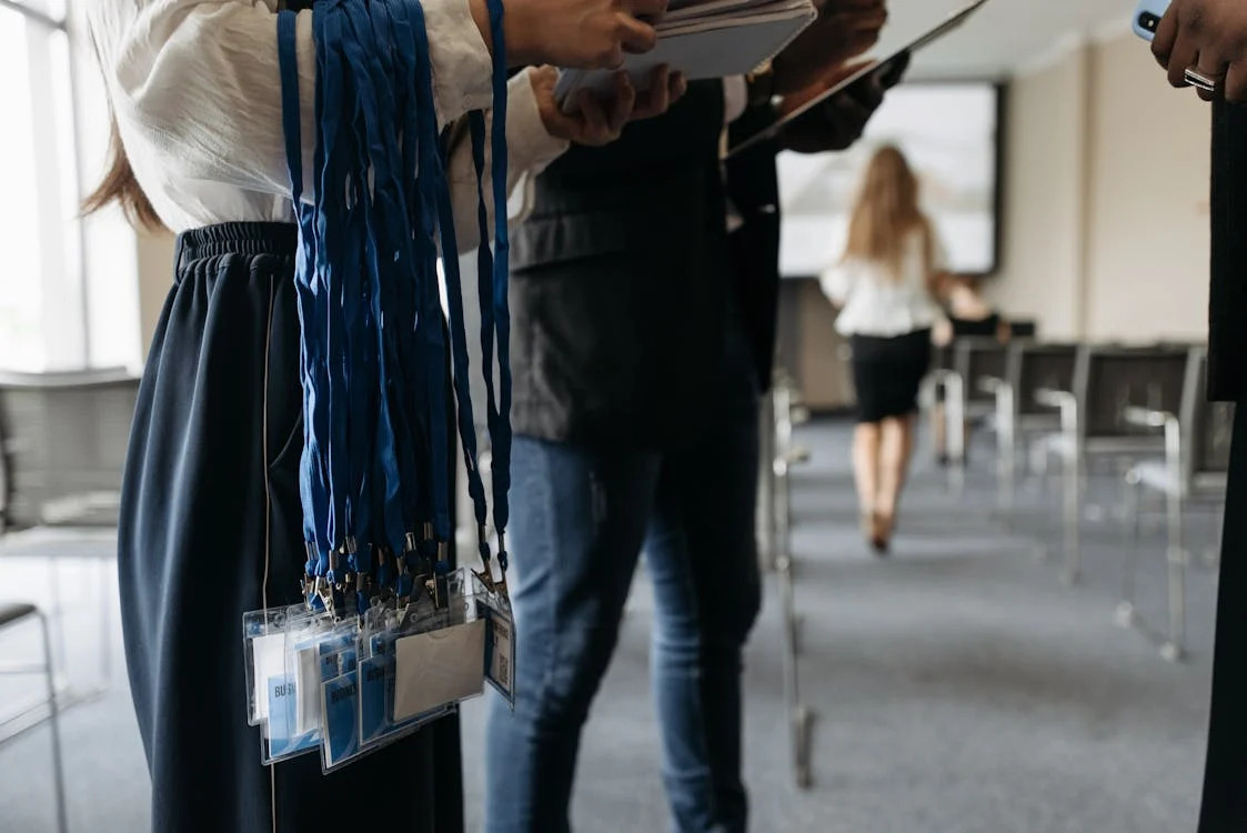 conference organizer holding badges on lanyards