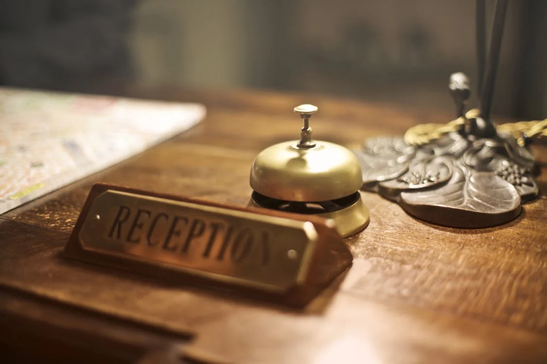 up-close view of hotel reception desk with antique bell